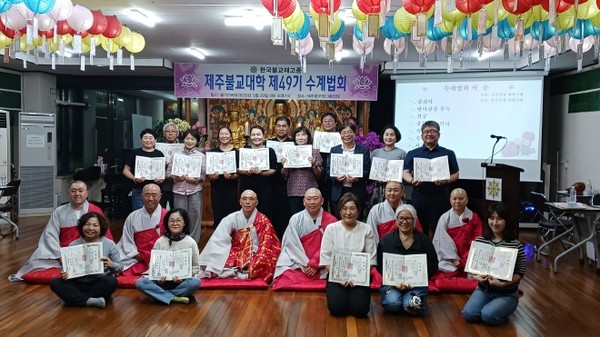 제주불교대학장 휴완 스님을 중심으로 수계자들이 전체 기념촬영을 하고 있다.