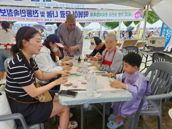 칠보공예 무료체험장에서 한 어린이가 엄마와 함께 실습을 하고 있다.