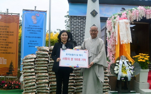 삼불암 회주 심월 스님이  영산대재를 봉행한 자리에서 김효순 전북 서부 보훈지청 보상과장에게 백미 100포를 전달하고 있다.
