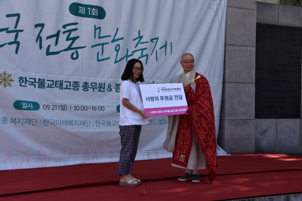 미혼모가족협의회에 후원금을 전달하고 있는 총무원장 상진 스님.