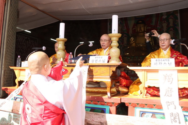 전계아사리 총무원장 상진 스님이 수계자 대표 범수 스님에게 수계증을 전달하고 있다.