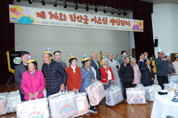 생일을 맞은 어르신들이 따뜻한 이불을 선물받고 기뻐하고 있다.