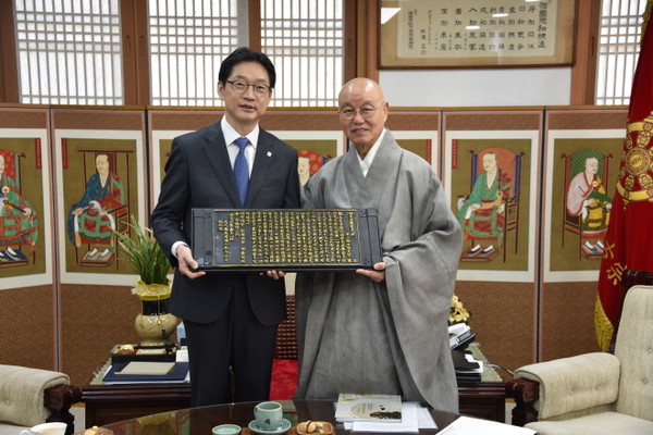 총무원장 상진 스님이 김경수 지방시대위원장에게 목판본 반야심경을 선물하고 있다.